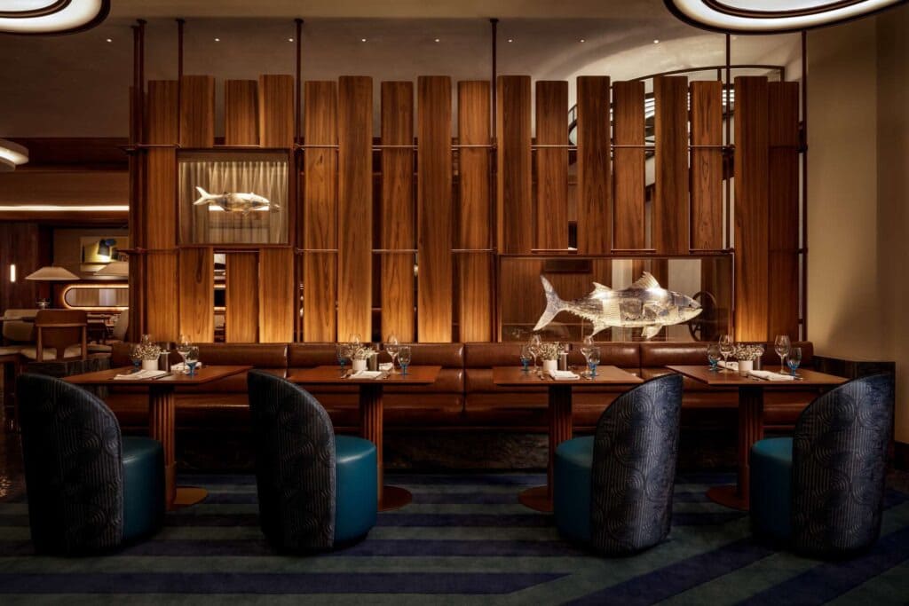 Restaurants at Encore Boston Harbor Resort Upscale dining space with modern wood paneling, fish sculptures, and plush seating.